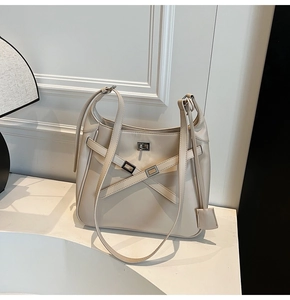Detail of cream leather bucket bag with silver metal twist lock and cross strap design