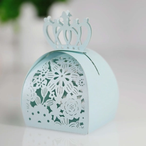 Detail of light blue laser-cut wedding candy box with elegant crown top and floral pattern
