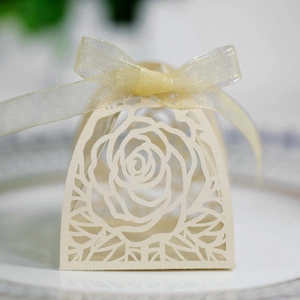Dettaglio scatola regalo rosa tagliata al laser crema con elegante fiocco in organza