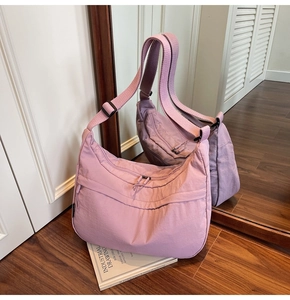 Détail du sac hobo mauve avec bandoulière réglable et poche zippée sur le devant