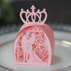 Pink laser-cut wedding candy box with Mr & Mrs crown design on a white ceramic plate