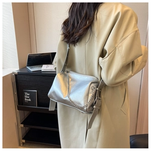 Rear view of a model wearing a stylish silver metallic shoulder bag with chain detail