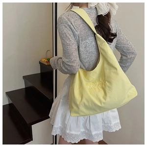 Detail of light yellow MVICHI tote bag with letter embroidery and wide shoulder strap