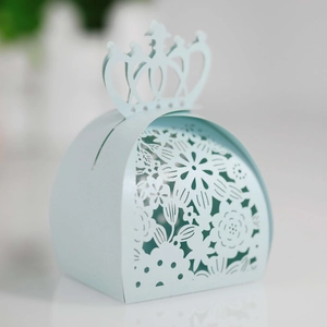 Macro view of laser-cut floral patterns and crown top on light blue wedding favor box