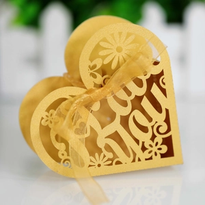 Macro shot of gold heart-shaped laser-cut gift box with Thank You cutout and ribbon