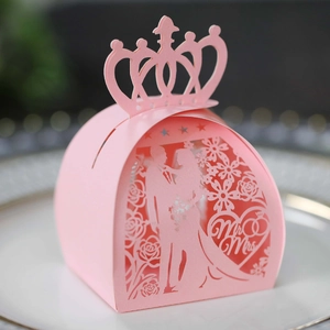Macro detail of pink laser-cut wedding favor box with Mr & Mrs silhouette and crown top
