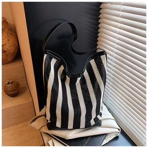 Détail du sac seau en maille à rayures noires et blanches avec texture lisse et filet tissé