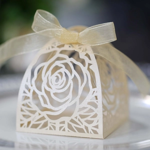 Dettaglio scatola porta confetti rosa intagliata a laser con nastro di organza dorato