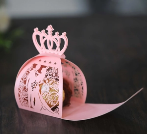 Detailed laser-cut pink carriage wedding favor box with Mr & Mrs silhouette and crown top