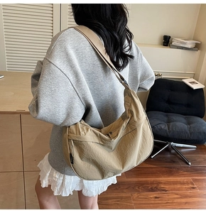 Mannequin portant un sac besace en nylon kaki avec une large bandoulière réglable