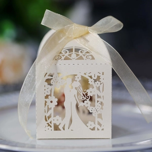 Close-up of laser-cut wedding favor box with bride and groom silhouette and ribbon bow