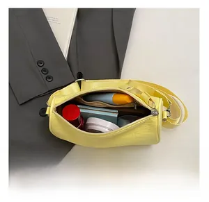 Internal capacity of yellow pleated nylon cylinder bag with cosmetics and skincare items