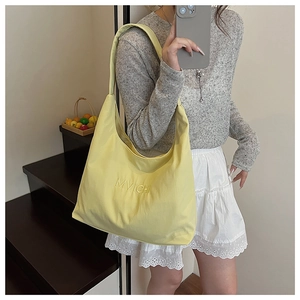 Mirror selfie showing a yellow shoulder tote bag with MVICH lettering for daily commuting