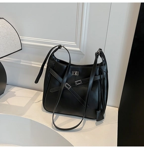 Close-up of matte black leather bucket bag with silver buckle and sleek cross straps