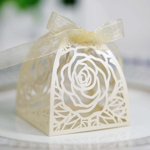 Macro dei motivi a rosa tagliati al laser su eleganti scatole regalo color avorio per nozze