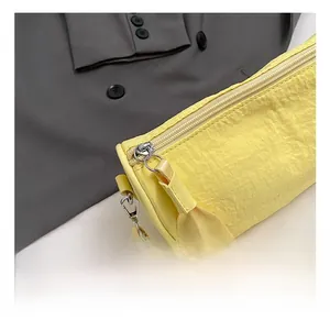 Detail shot of the metallic silver zipper and yellow pleated nylon fabric on the pillow bag