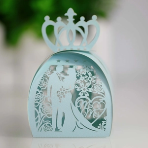 Macro detail of laser-cut wedding favor box with groom and bride silhouette in light blue