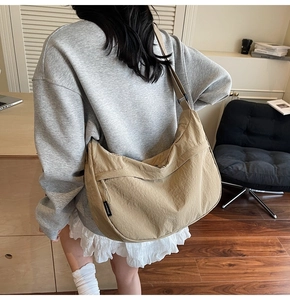 Détail de la bandoulière réglable et de l'étiquette sur le sac hobo en nylon