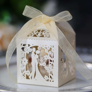 Macro view of laser-cut wedding favor box featuring bride and groom silhouette detail