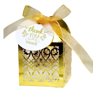 Golden laser-cut European wedding favor box with ribbon and thank you tag on white background