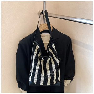 Détail du sac fourre-tout en maille rayée avec bordure en similicuir et bandoulière