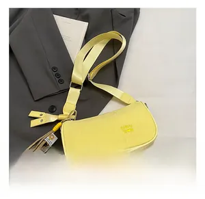 Detail of light yellow PU pillow bag with CHUU 'D N logo and wide fabric strap