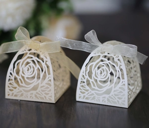 Dettaglio di scatole per confetti traforate al laser con fiocchi in organza
