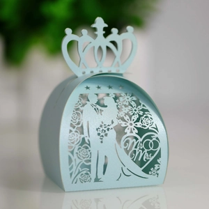 Macro shot of light blue laser-cut wedding favor box with crown top and Mr & Mrs design