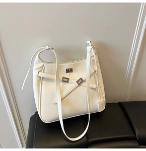 Detailed macro view of white PU leather texture and silver twist lock on shoulder bag