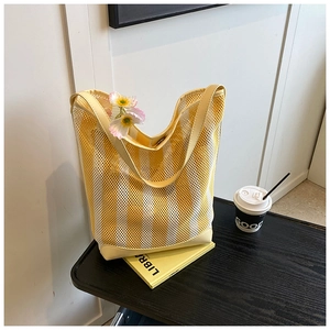 Gros plan du sac fourre-tout en maille rayée jaune avec fermoir magnétique en métal