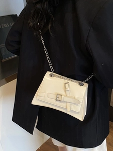 Modern cream leather crossbody bag with silver buckle straps and chain strap detail
