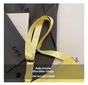 Detail of adjustable nylon shoulder strap with silver metal buckle on a yellow crossbody bag