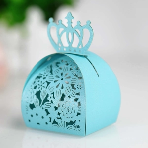 Detail view of light blue laser-cut candy box with crown handle and hollow floral pattern