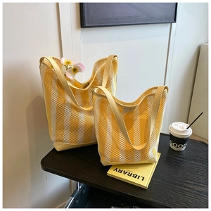 Détail de deux sacs seaux en maille rayée jaune et blanc avec poignées renforcées
