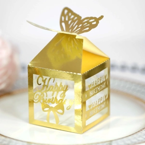 Macro detail of laser-cut gold gift box featuring hollow Happy Birthday text and 3D butterfly