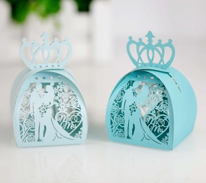 Detailed close-up of light blue laser-cut wedding favor boxes with Mr & Mrs heart patterns