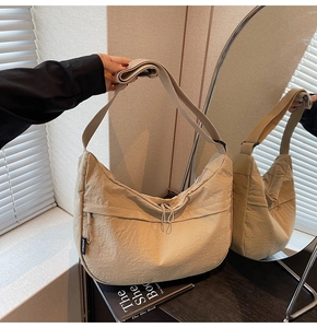 Détail du sac beige en nylon avec bandoulière réglable et fermeture éclair décorative