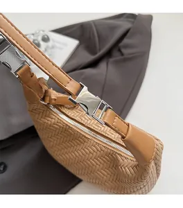 Close-up of tan woven leather handbag texture with premium silver metal buckle