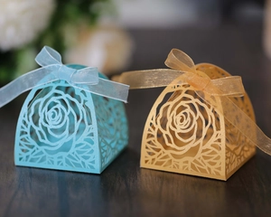 Dettagli di rose intagliate al laser e nastri su scatole regalo blu e dorate