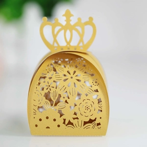 Close-up of laser-cut crown favor box with intricate floral hollow patterns in bright yellow
