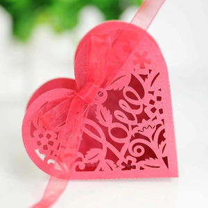 Detailed laser-cut flower patterns and LOVE text on a pink heart candy box with ribbon