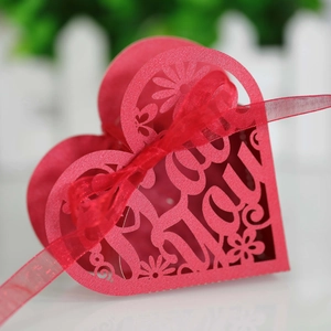 Close-up of laser-cut red heart gift box with I Love You text and matching red ribbon