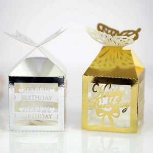 Macro detail of laser-cut butterfly gift boxes in metallic gold and silver finish