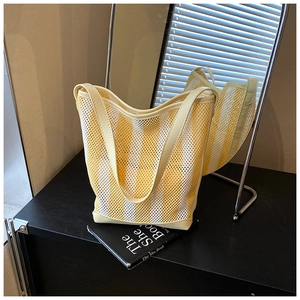 Détail du sac fourre-tout en maille à rayures jaunes et blanches avec poignées renforcées