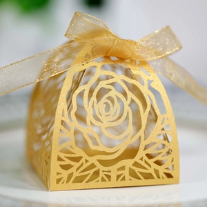 Dettaglio della scatola di caramelle dorata con intaglio laser a rosa e nastro