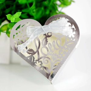 Detailed laser-cut silver heart favor box with Love script and light blue ribbon bow