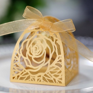 Dettaglio del motivo a rosa dorata tagliata al laser e nastro di chiffon sulla scatola
