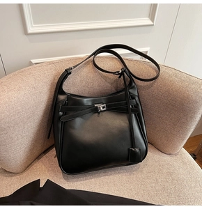 Detail of black matte leather hobo bag with silver metallic twist lock and adjustable strap