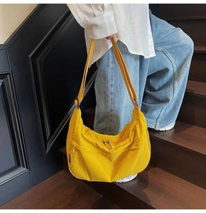 Détail du sac bandoulière en nylon jaune vif avec sangle réglable et fermeture éclair