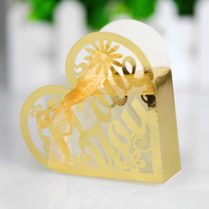 Macro shot of gold heart-shaped candy box with laser-cut Love You design and ribbon